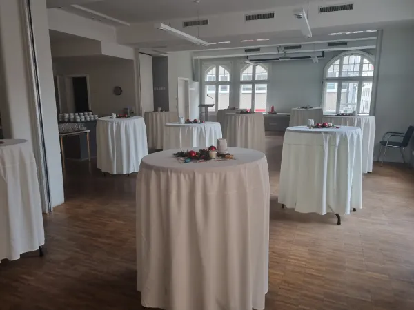 Blick in den Festsaal im Marienwerkhaus mit weihnachtlich geschmückten Stehtischen